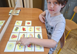 Na tym zdjęciu widać Tymka z grupy IV podczas ćwiczeń z kartami obrazkowymi.