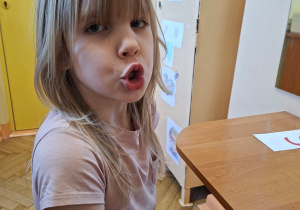 Zdjęcie przedstawia Wandę z grupy IV wykonującą ćwiczenia narządów mowy.