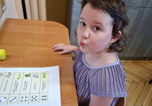 Na tym zdjęciu widać Lilę z grupy III podczas wykonywania ćwiczeń narządów mowy z przyborem.