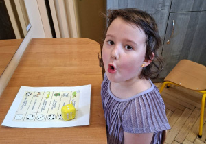 Na tym zdjęciu widać Lilę z grupy III podczas wykonywania ćwiczeń narządów mowy z przyborem.