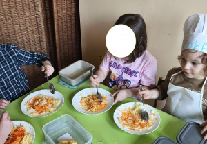 Zdjęcie przedstawia Adama M. i MIkołaja z grupy III z koleżanką mieszających składniki surówki.