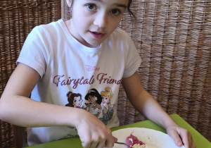 Zdjęcie przedstawia Marcelinę Ł. z grupy IV, która miesza składniki pasty z twarodu i rzodkiewki.