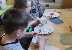 Zdjęcie przedstawia Stasia W., Julka Ch. i Wandę z grupy IV, którzy mieszają składniki twarożku.