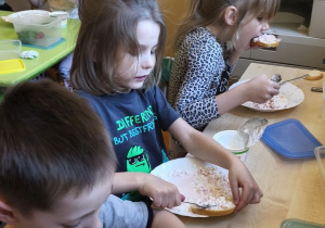 Zdjęcie przedstawia Stasia W., Julka Ch. i Wandę z grupy IV podczas degustacji kanapeczek.