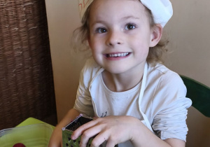 Na tym zdjęciu widać Oliwię z grupy III, która ściera na tarce rzodkiewkę.