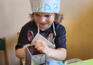 Na tym zdjęciu widać Mikołaja z grupy III, który ściera na tarce rzodkiewkę.