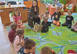 Zdjęcie przedstawia prowadzącą warsztaty oraz dzieci siedzące w kole.