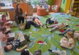 Na tym zdjęciu widać dzieci leżące na dywanie podczas słuchania opowiadania.