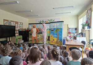 Na tym zdjęciu widać na scenie tygryska i prosiaczka, a na widowni dzieci.