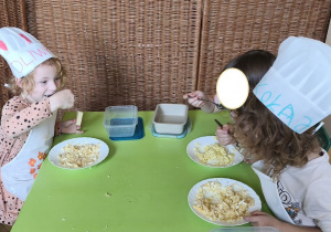 Zdjęcie przedstawia Oliwię, Mikołja z grupy III z koleżanką degustujących pastę jajeczną.