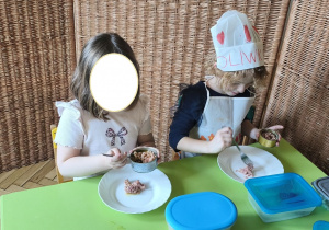 Na tym zdjęciu widać Oliwię z koleżanką z grupy III, które wykładają tuńczyka z puszki na talerz.