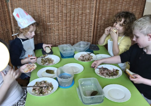 Na tym zdjęciu widać czworo dzieci z grupy III podczas degustacji kanapek z pastą z tuńczyka.