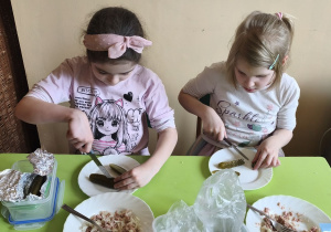 Na tym zdjęciu widać Marcelinę Ł. i Wandę z grupy IV, które kroją ogórka kiszonego w kostkę.