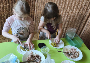 Na tym zdjęciu widać Klarę J. i Alę W. z grupy IV, które kroją ogórka kiszonego w kostkę.