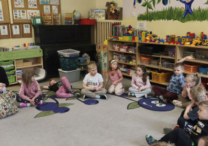 Zdjęcie przedstawia dzieci siedzące w kole oraz prowadzącą warsztaty.