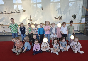 Zdjęcie przedstawia dzieci z grupy I oczekujące na spektakl we foyer teatru.