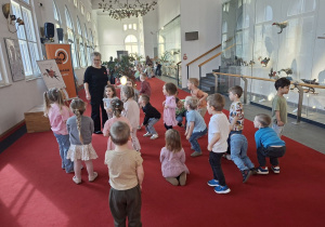 Na tym zdjęciu widać dzieci z grupy I podczas zabaw we foyer zorganizowanych przez panią z obsługi teatru.