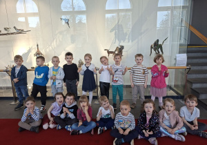 Zdjęcie przedstawia dzieci z grupy II oczekujące na spektakl we foyer teatru.