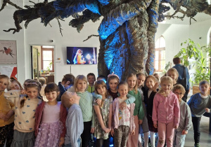 Zdjęcie przedstawia dzieci z grupy IV pod magicznm drzewem znajdującycm się w holu przy wejściu.