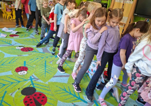 Na tym zdjęciu widać dzieci ustawioen w "pociąg" podczas zabawy ruchowej.