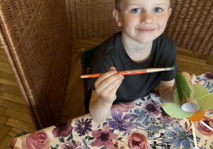 Zdjęcie przedstawia jednego z chłopców z grupy III wykonującego ćmę z rolki po papierze.