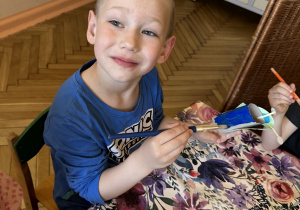 Na tym zdjęciu widać Oskara z grupy III malującego rolkę po papierze potrzebną do wykonania ćmy.