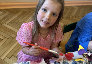 Zdjęcie przedstawia jedną z dziewczynek z grupy III wykonującą ćmę z rolki po papierze.