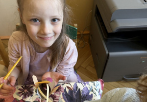 Na tym zdjęciu widać jedną z dziewczynek z grupy III malującą rolkę po papierze potrzebną do wykonania ćmy.