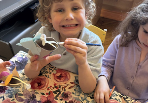 Zdjęcie przedstawia jdwoje dzieci z grupy III wykonujących ćmę z rolki po papierze.