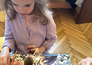 Zdjęcie przedstawia jedną z dziewczynek z grupy III wykonującą ćmę z rolki po papierze.