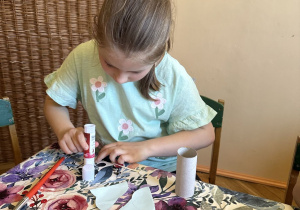 Zdjęcie przedstawia Basię z grupy IV wykonującą ćmę z rolki po papierze.