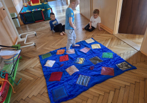 Zdjęcie przedstawia Kubę S. z grupy II podczas ćwiczeń integracji sensorycznej z wykorzystaniem dywanu sensorycznego.