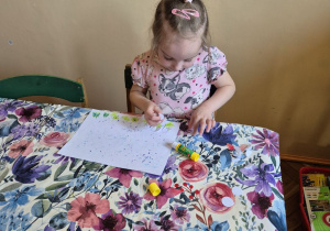 Zdjęcie przedstawia jedną z dziewczynek wykonującą przebiśniegi.