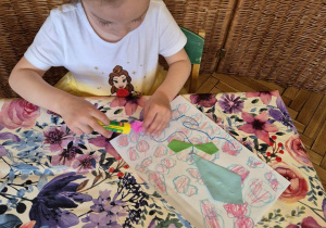 Na tym zdjęciu widać jedną z dziewczynek wykonującą latawiec metodą origami na bazie leniwych ósemek.