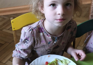 Zdjęcie przedstawia Oliwię z grupy III podczas degustacji sałatki z kapustą pekińską.