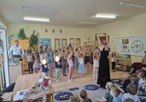 Na tym zdjęciu widać jedną z tancerek, która uczy dziewczynki wybranych figur czardasza.