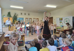 Na tym zdjęciu widać jedną z tancerek, która uczy dziewczynki wybranych figur czardasza.