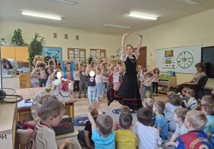 Na tym zdjęciu widać jedną z tancerek, która uczy dziewczynki wybranych figur czardasza.