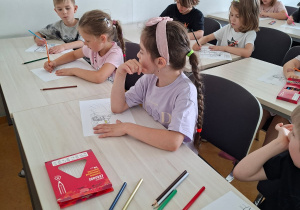 Na tym zdjęciu widać dzieci w jednej z sal wykładowych, kolorujące malowankę.