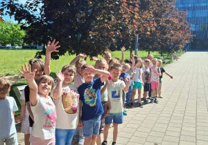 Zdjęcie przedstawia dzieci w drodze do budynku uczelni.