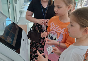 Zdjęcie przedstawia dzieci zwiedzające budynek uczelni.