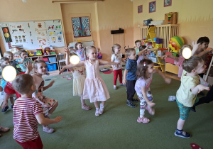 Na tym zdjęciu widać mamę Mikołaja oraz dzieci podczas zabawy ruchowej przy muzyce.