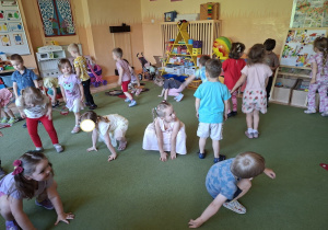 Na tym zdjęciu widać mamę Mikołaja oraz dzieci podczas zabawy ruchowej przy muzyce.