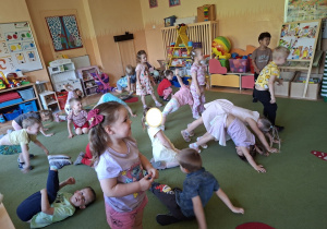 Na tym zdjęciu widać mamę Mikołaja oraz dzieci podczas zabawy ruchowej przy muzyce.