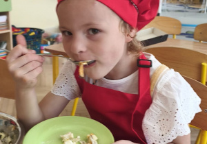 Zdjęcie przedstawia Oliwię z grupy III degustującą wykonaną przez siebie sałatkę jarzynową.