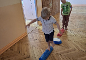 Na tym zdjęciu widać Henia D. i Damiana z grupy I wykonujących ćwiczenia z wykorzystaniem kamieni rzecznych i ścieżki sensorycznej.