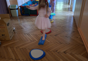 Na tym zdjęciu widać Natalkę z grupy I wykonującą ćwiczenia z wykorzystaniem kamieni rzecznych i ścieżki sensorycznej.
