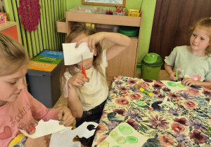 Zdjęcie przedstawia trzy dziewczynki z grupy IV biorące udział w projekcie. wykonujące pracę.