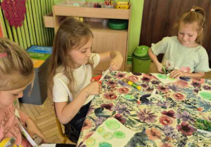 Zdjęcie przedstawia trzy dziewczynki z grupy IV biorące udział w projekcie. wykonujące pracę.