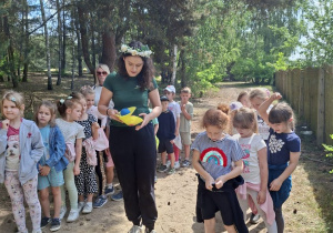 Zdjęcie przedstawia dzieci biorące udział w konkurencji sportowej: przenoszenie piłeczek na krążkach.